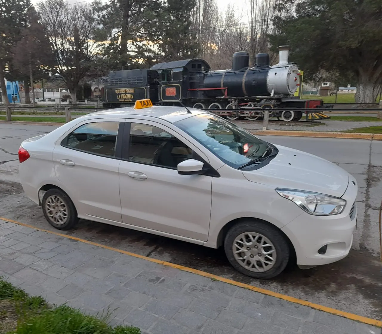 Taxi Segura estacionado frente a la locomotora de La Trochita en Esquel